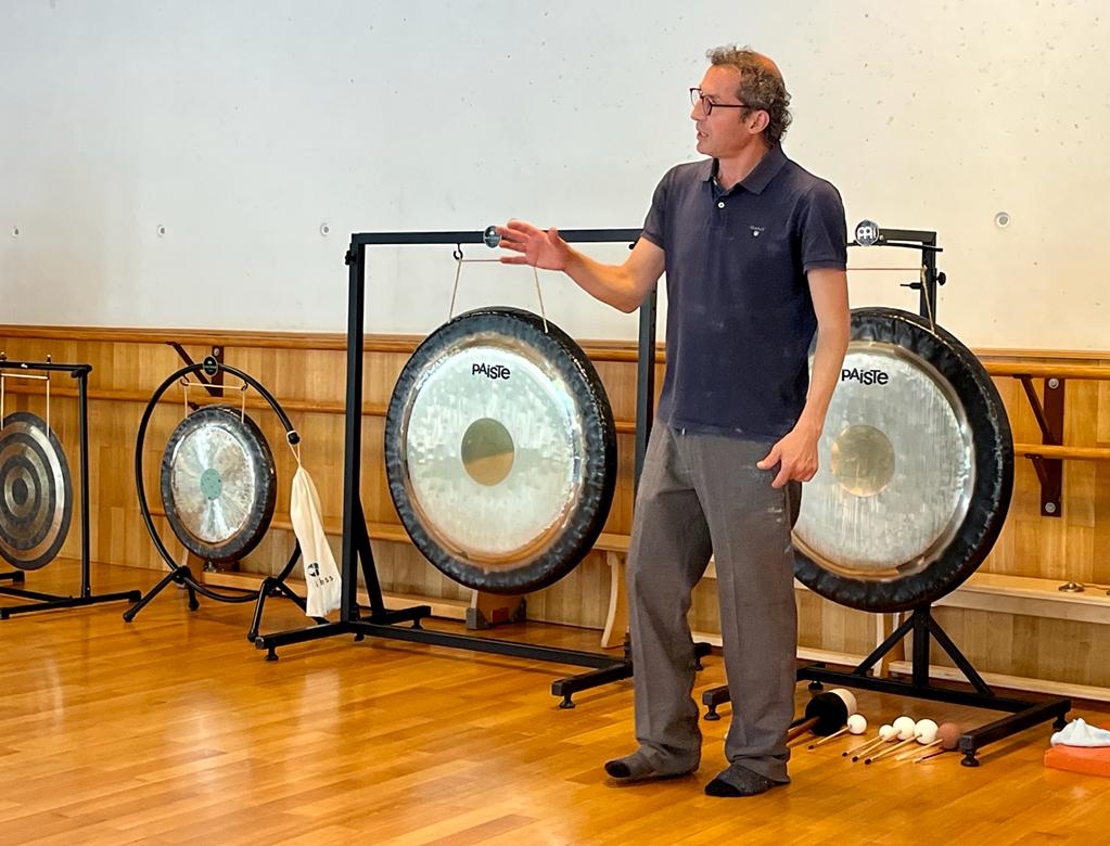 Othman Haddad enseignant à côté de deux gongs lors d’une formation privée en sonothérapie